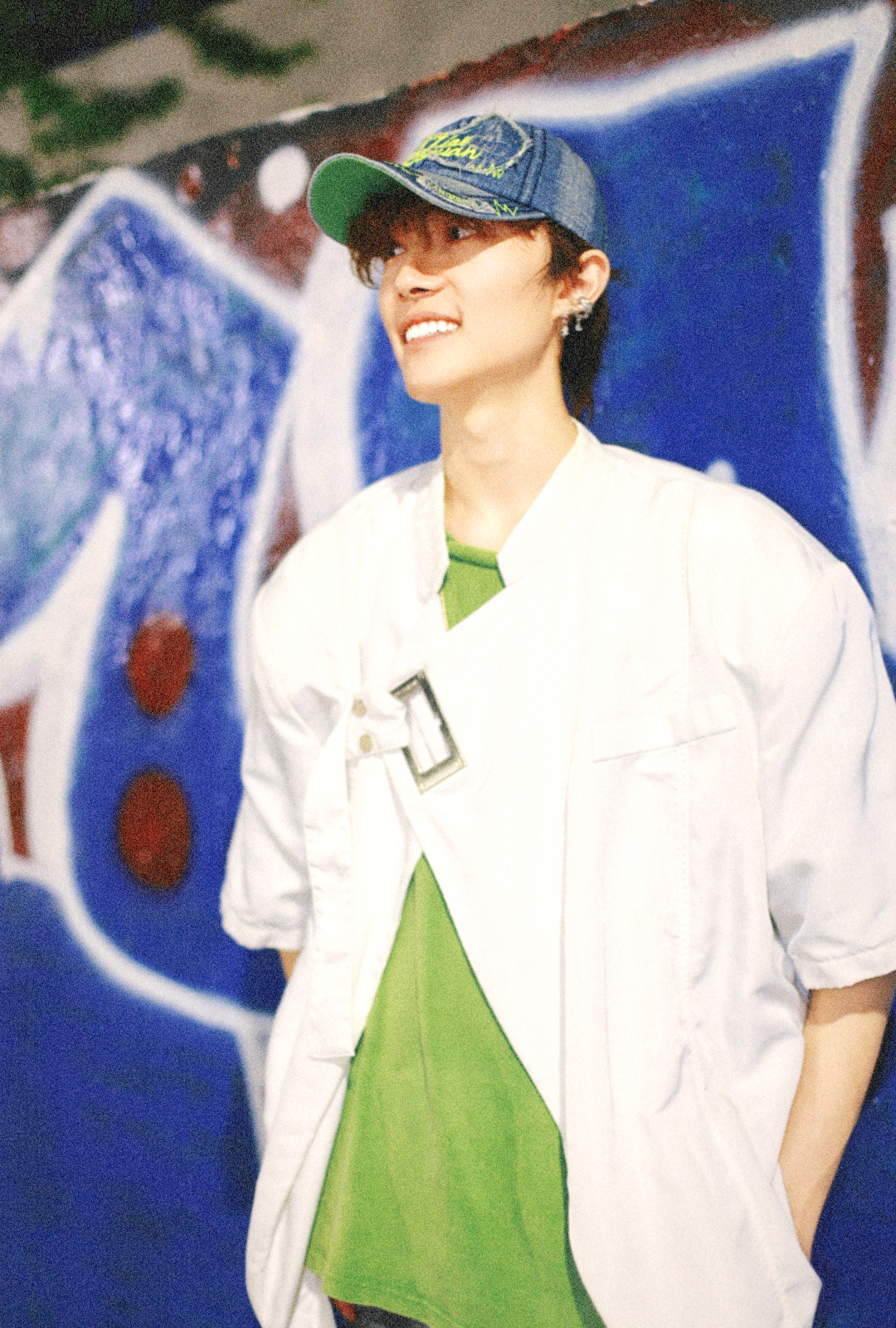 Qingrui Lou standing in front of a blue mural