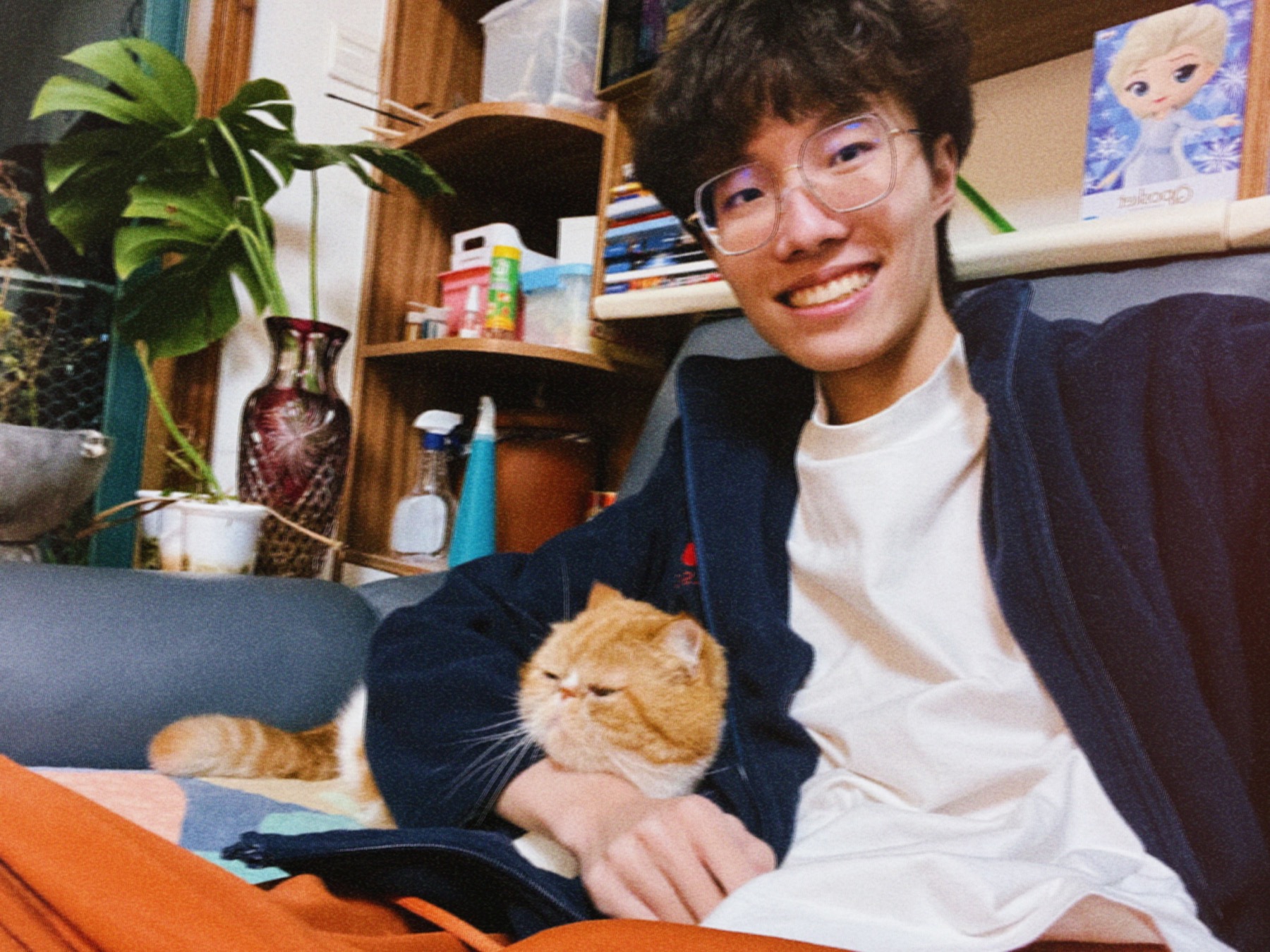Qingrui Lou sitting at home with an orange cat